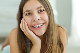 Orthodontist holding model of teeth with braces