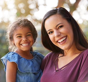 Child and mom smiling outside