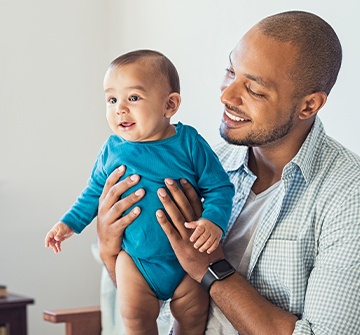 Father holding baby during dentistry for infants visit