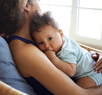 Mother holding teething baby