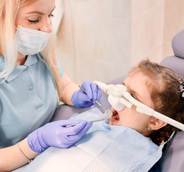 happy child after dental treatment looking in mirror