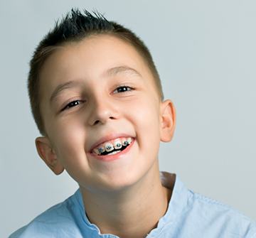 Smiling young boy with Phase 1 Orthodontics in Clinton 