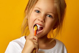 Young girl looking at camera while eating lunch at school