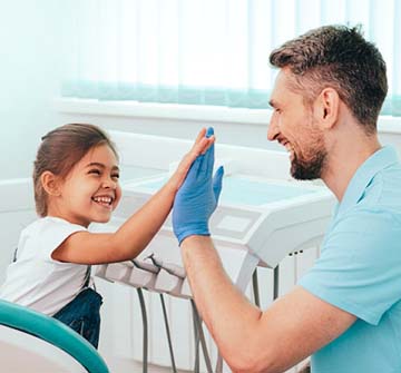 Pediatric dentist in Clinton high-fiving child