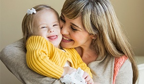 Mother giving daughter kiss on cheek after sedation dentistry visit