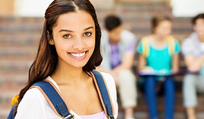 Young woman smiling outdoors after dentistry for teens visit