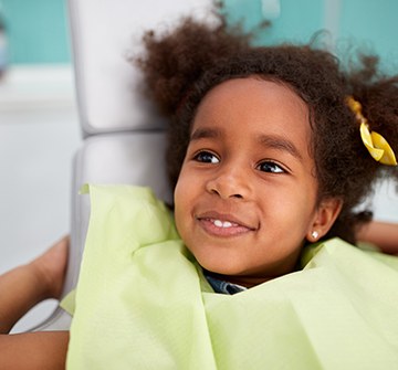 Toddler smiling during dental checkups and teeth cleanings