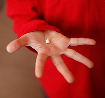 Person holding a tooth after extraction