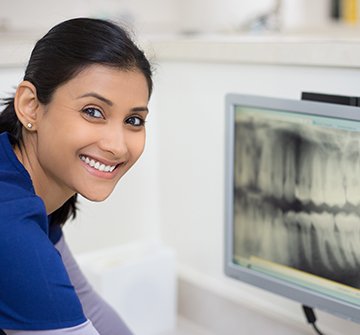 Dental team member looking at digital x-rays