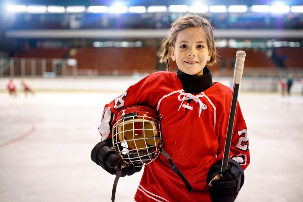 Closeup of kid smiling in hockey uniform