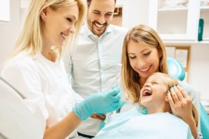 Child, family, and dentist smiling from pediatric dentistry