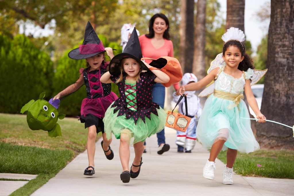 Children smiling while trick-or-treating with friends